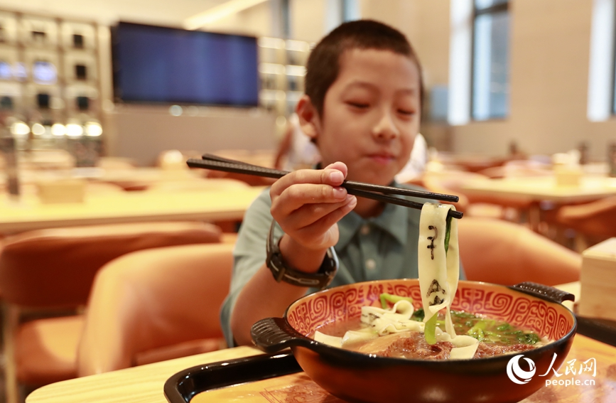 殷墟博物館推出的甲骨文面深受游客喜愛。人民網(wǎng)記者 慎志遠(yuǎn) 攝